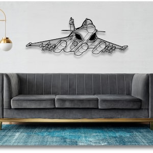 May include: A black metal wall art sculpture of a fighter jet, with a grey sofa and a blue rug in the background.