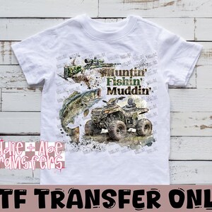 May include: White t-shirt with a green, brown, and black graphic print of a fish, an ATV, and a rifle. The text "Huntin' Fishin' Muddin'" is printed on the shirt.