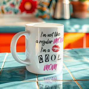 A sleek colorful kitchen with the "I'm Not Like a Regular Mom, I'm a Cool Mom" mug sitting on the counter, emphasizing its durable, dishwasher-safe, and microwave-friendly design. This mug is perfect for daily use and a fun addition to any mom’s coffee routine.