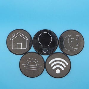 Puede incluir: Cinco iconos de hogar inteligente circulares de color gris oscuro con contornos blancos. Los iconos incluyen una casa, una bombilla, una luna creciente con Z, un amanecer y un símbolo Wi-Fi. Los iconos están sobre un fondo azul claro.
