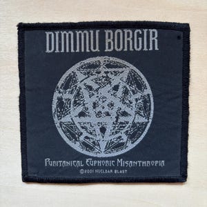 May include: A square black fabric patch featuring the grey text DIMMU BORGIR at the top and PURITANICAL EUPHORIC MISANTHROPIA at the bottom. In the centre is a circular grey graphic of a pentagram. The text ©2001 NUCLEAR BLAST is printed below.