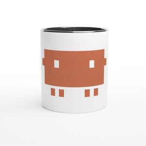 Op de afbeelding: Witte keramische mok met een roestkleurig gepixeld ontwerp. De mok heeft een zwarte rand en een wit interieur. Het ontwerp heeft een rechthoekige vorm met twee vierkante pixels boven en twee onder.