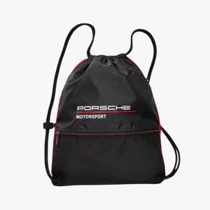 Puede incluir: Bolsa de cordón negra con ribete rojo y un logotipo blanco de "Porsche Motorsport".