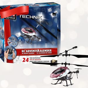 Puede incluir: Un helicóptero RC rojo y blanco con aspas negras se muestra junto a su caja. La caja está etiquetada como "RC Adventskalender" y presenta imágenes del helicóptero y un mando a distancia. La caja tiene una cinta roja en la parte superior.