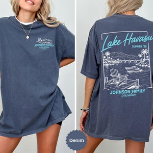 Puede incluir: Una camiseta color mezclilla con un peque&ntilde;o gr&aacute;fico en el pecho con el texto Johnson Family Vacation 2026. La parte posterior muestra un gran gr&aacute;fico rectangular de Lake Havasu, Summer '26, con un muelle, una silla, un barco y palmeras.