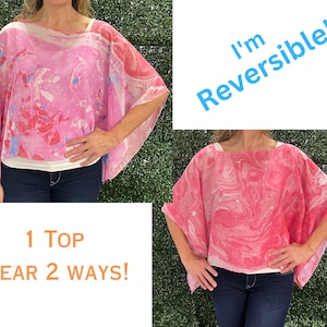 May include: A pink and white reversible top with a marbled pattern. The top is shown being worn by two different people, with the pattern facing opposite directions. The text "I'm Reversible!" is written in blue on a white background. The text "1 TOP WEAR 2 WAYS!" is written in orange on a white background.