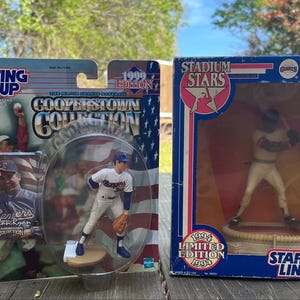 Puede incluir: Dos figuras de jugadores de béisbol en su embalaje original. Una es una figura de Nolan Ryan de la colección Cooperstown de 1999. La otra es una figura de edición limitada de Barry Bonds de 1994 de la colección Stadium Stars.