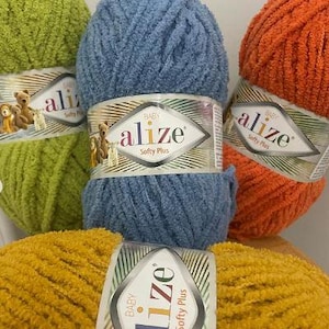 May include: Four skeins of yarn in different colors: green, blue, orange, and yellow. The yarn is soft and fluffy, and the labels say "Baby Alize Softy Plus".