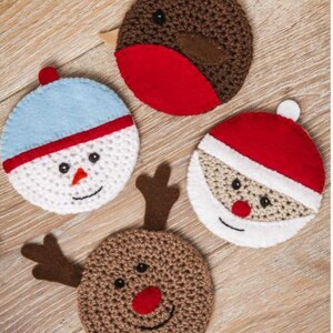 Peut inclure: Quatre dessous de verre de Noël faits à la main. L'un est un rouge-gorge marron avec une poitrine rouge, un autre est un bonhomme de neige avec un chapeau bleu, un Père Noël et un renne avec des bois et un nez rouge. Les dessous de verre sont en crochet et en feutre.
