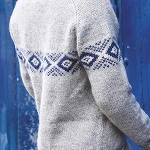 Peut inclure: Un pull en tricot gris avec un motif géométrique bleu et blanc autour de la taille. Le pull a un col montant et des manches longues.