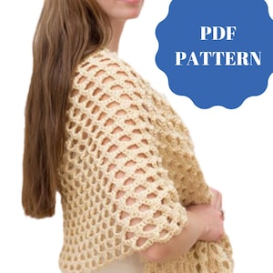 Puede incluir: Un patrón de chal de ganchillo en formato PDF. El patrón presenta un chal de ganchillo beige con un delicado diseño de calado.