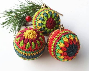 May include: Three crocheted Christmas baubles in red, green, yellow, and blue. The baubles are round and have a textured surface.