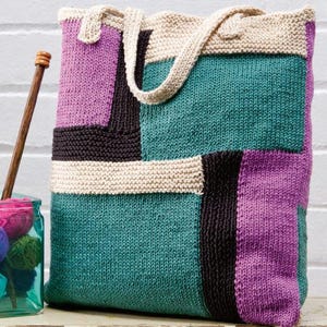 May include: A knitted tote bag with a patchwork design in shades of teal, purple, brown, and cream. The bag has two straps and is made with a chunky yarn.