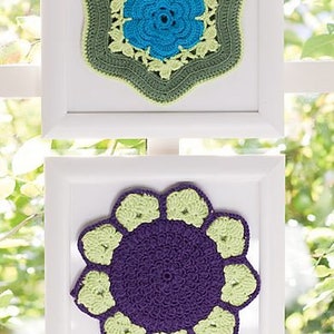 May include: Two crocheted flower designs in white frames. The top design is a green and blue flower with a star-shaped outline. The bottom design is a purple flower with green petals.