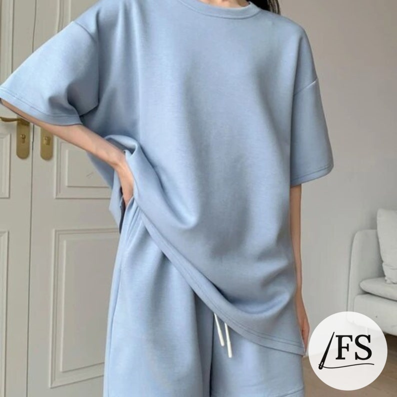 May include: A light blue short-sleeved t-shirt and matching shorts set. The set is made of a soft, comfortable fabric and has a relaxed fit.