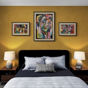 Puede incluir: Un dormitorio con una pared de color amarillo mostaza y tres pinturas abstractas de rostros. La cama tiene una cabecera negra y un edred&oacute;n a rayas azul marino y blanco. Hay dos mesitas de noche con l&aacute;mparas.