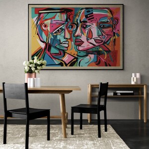 Puede incluir: Pintura abstracta de dos caras, una masculina y una femenina, con colores vivos y formas geom&eacute;tricas. La pintura est&aacute; enmarcada en negro y colgada en una pared gris.