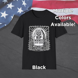 May include: Black t-shirt with a white graphic of a tombstone with the text "RIP WOKENESS 2015-2024". The text "Multiple Colors Available!" is in the top right corner of the image. The text "Black" is at the bottom of the image.