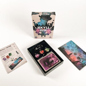 Könnte beinhalten: Eine Brettspielbox mit einem Schwarzweißbild eines Mannes vor einem dunklen Hintergrund. Die Box ist mit "Jekyll & Hyde" beschriftet. Das Spiel enthält eine schwarze Box mit Spielfiguren, eine Spielanleitung und eine Karte mit dem Porträt eines Mannes.