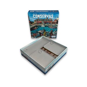 May include: A board game box and its contents are shown. The box, labelled "CONSERVAS," depicts a harbour scene with boats and people. Inside, there are several grey, tin-like containers, suggesting a food-themed game. The game is from Twisted Games.