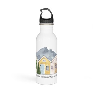 Op de afbeelding: Een witte waterfles van roestvrij staal met een zwarte dop en een draaggreep. De fles heeft een aquarel-illustratie van een rij kleurrijke huizen met een berg op de achtergrond. De tekst "to house they continued without" staat gedrukt op de onderkant van de fles.
