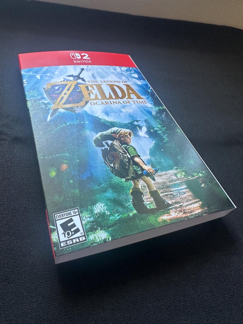 May include: A rectangular video game case for The Legend of Zelda: Ocarina of Time for Nintendo Switch. The cover features a green-clad character standing on a path in a forest, the game title in gold text, and an ESRB Everyone 10+ rating logo.