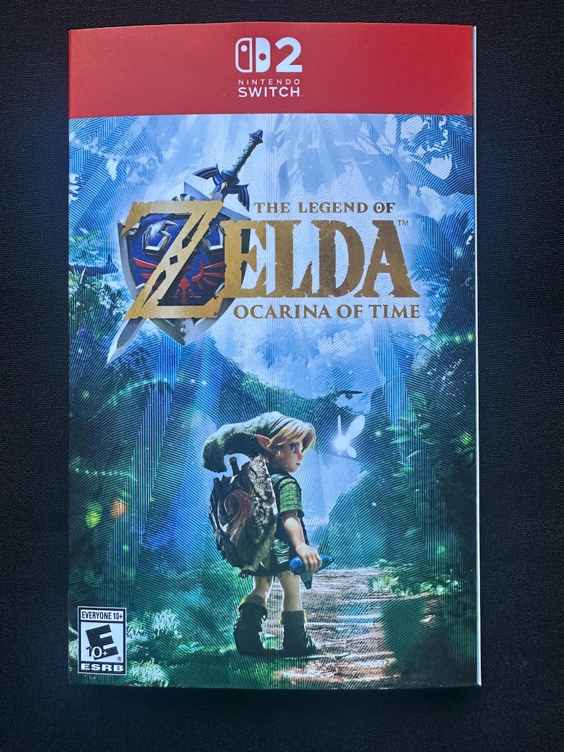 May include: A Nintendo Switch game case cover for The Legend of Zelda: Ocarina of Time. The artwork features a character in green clothing standing on a path, a sword and shield emblem, and the ESRB Everyone 10+ rating logo in the corner.