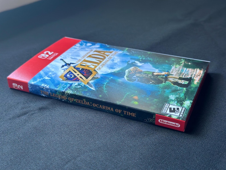May include: A Nintendo Switch game case for The Legend of Zelda: Ocarina of Time. The cover features a green forest scene with a character, the game title in gold lettering, and the Nintendo Switch logo. The spine displays the game title clearly.