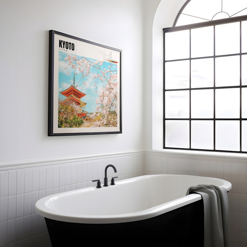 a bathroom with a black and white bathtub and a picture on the wall