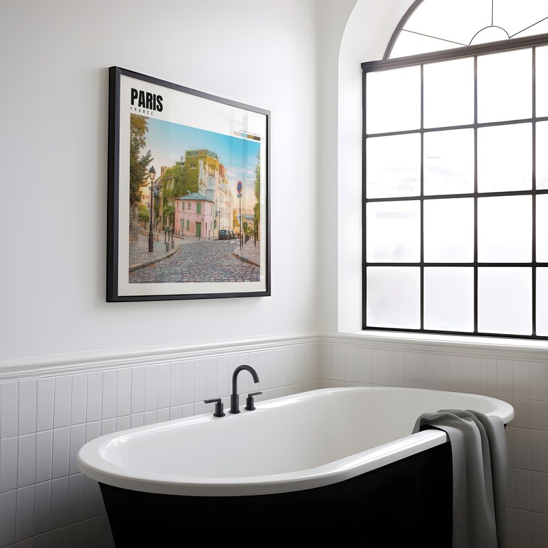 a bathtub in a bathroom with a picture on the wall