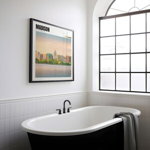 a bathtub in a bathroom with a picture on the wall