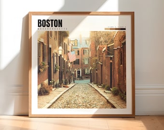 May include: A photograph of a cobblestone street in Boston, Massachusetts. The street is lined with brick buildings and there is an American flag hanging from a building. The street is empty except for a few people walking in the distance.