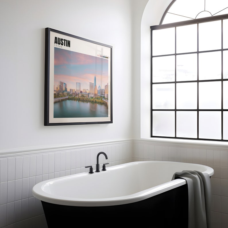 a bathtub in a bathroom with a picture on the wall