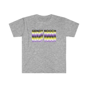 May include: Grey t-shirt with the text "GENDY NOOCH" in black letters with a purple, yellow and black striped design behind the text.