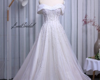 A-line white wedding dress with seductive, off-the-shoulder design. Custom wedding dress meticulously hand-embellished.