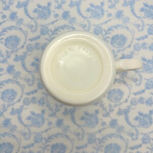 May include: White ceramic mug with the words "Cobal  French" printed on the bottom.