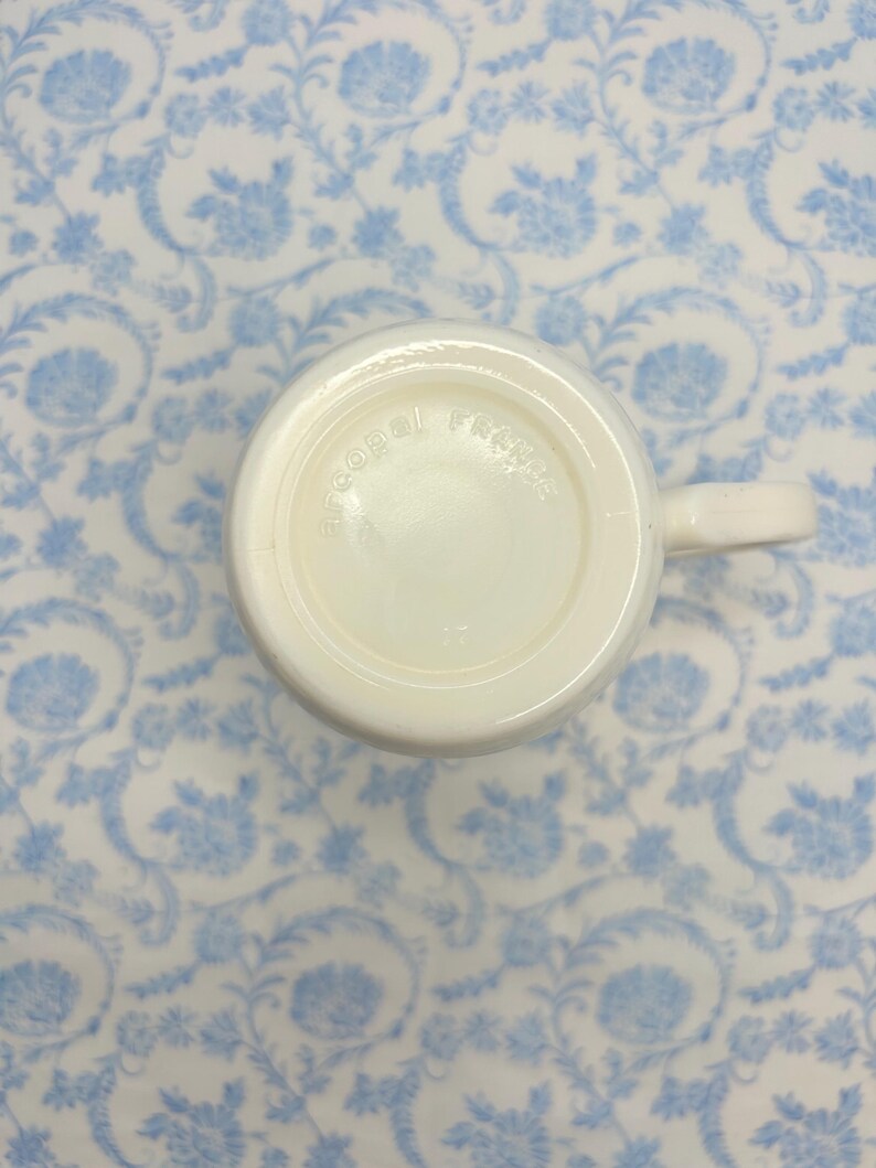 May include: White ceramic mug with the words "Cobal  French" printed on the bottom.