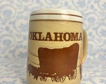 May include: A set of three ceramic mugs with a speckled, matte finish. The mugs are in shades of cream, light gray, and dark gray. Each mug has a simple, minimalist design, perfect for coffee or tea.