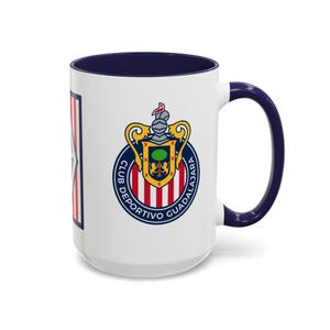 May include: White ceramic mug with a navy blue interior and handle. The mug features the Club Deportivo Guadalajara logo, a crest with a knight's helmet, and the words "CLUB DEPORTIVO GUADALAJARA" in a circular design.