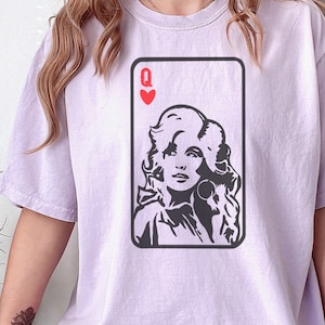 Peut inclure: T-shirt lilas avec un portrait en noir et blanc d'une femme dans un motif de carte &agrave; jouer. La carte est la Dame de c&oelig;ur. Le t-shirt est de style d&eacute;contract&eacute;.