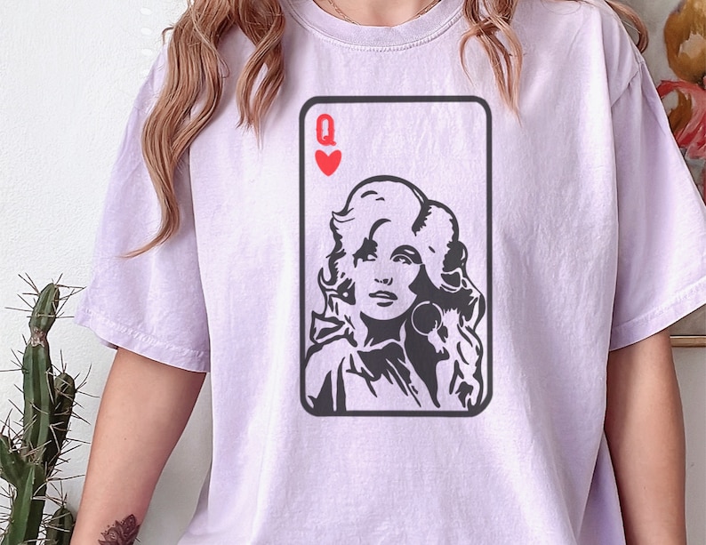 Peut inclure: T-shirt lilas avec un portrait en noir et blanc d'une femme dans un motif de carte &agrave; jouer. La carte est la Dame de c&oelig;ur. Le t-shirt est de style d&eacute;contract&eacute;.