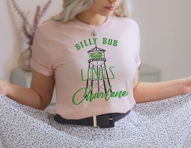 May include: A pink t-shirt with a green graphic of a water tower with the text "Billy Bob Loves Charlene" on it.