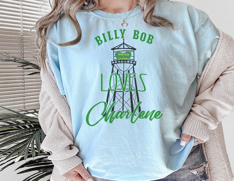 May include: A light blue t-shirt with a graphic of a water tower that says "Billy Bob Charlene" and the text "Billy Bob Loves Charlene".