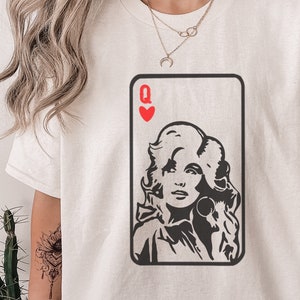 Peut inclure: T-shirt cr&egrave;me avec un motif de carte &agrave; jouer repr&eacute;sentant le portrait d'une femme et le symbole de c&oelig;ur rouge et la lettre "Q". Le graphisme est en noir et blanc.