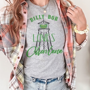 May include: Gray t-shirt with a graphic of a water tower and the text "Billy Bob Loves Charlene".