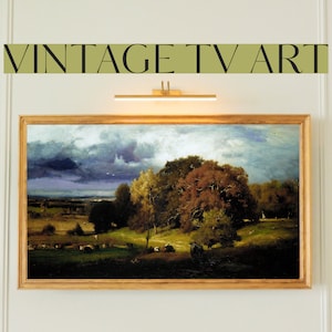 Puede incluir: Una pintura enmarcada que representa un paisaje con un cielo nublado, árboles y vacas en un campo. La pintura está en un marco dorado y está colgada en una pared blanca.