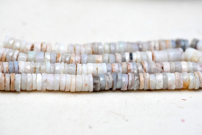 Pu&ograve; includere: Un filo di perle di opale bianco con forma irregolare e sfaccettata. Le perle misurano circa 4 mm e hanno un leggero bagliore iridescente.