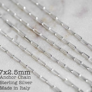 May include: Close-up of a silver 7x2.5mm anchor chain necklace. The chain is made of sterling silver and is made in Italy.
