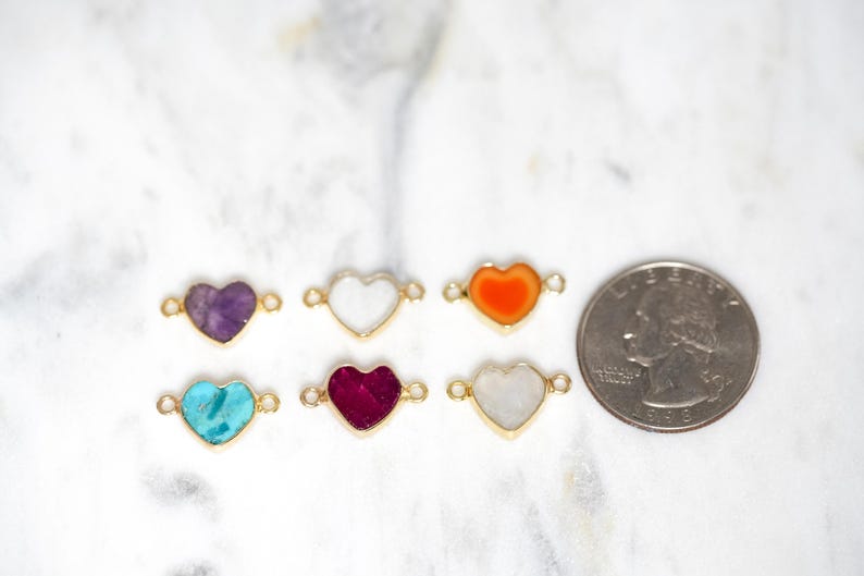 Pu&ograve; includere: Sei ciondoli a forma di cuore con pietre di diversi colori, tra cui viola, bianco, arancione, turchese, rosso e bianco. I ciondoli sono circa delle dimensioni di una moneta da 25 centesimi di dollaro americano.