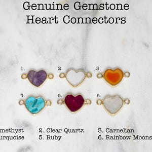 Pu&ograve; includere: Sei connettori a forma di cuore in pietra preziosa con anelli a salto in oro. Le pietre preziose sono ametista, quarzo trasparente, corniola, turchese, rubino e pietra di luna arcobaleno.